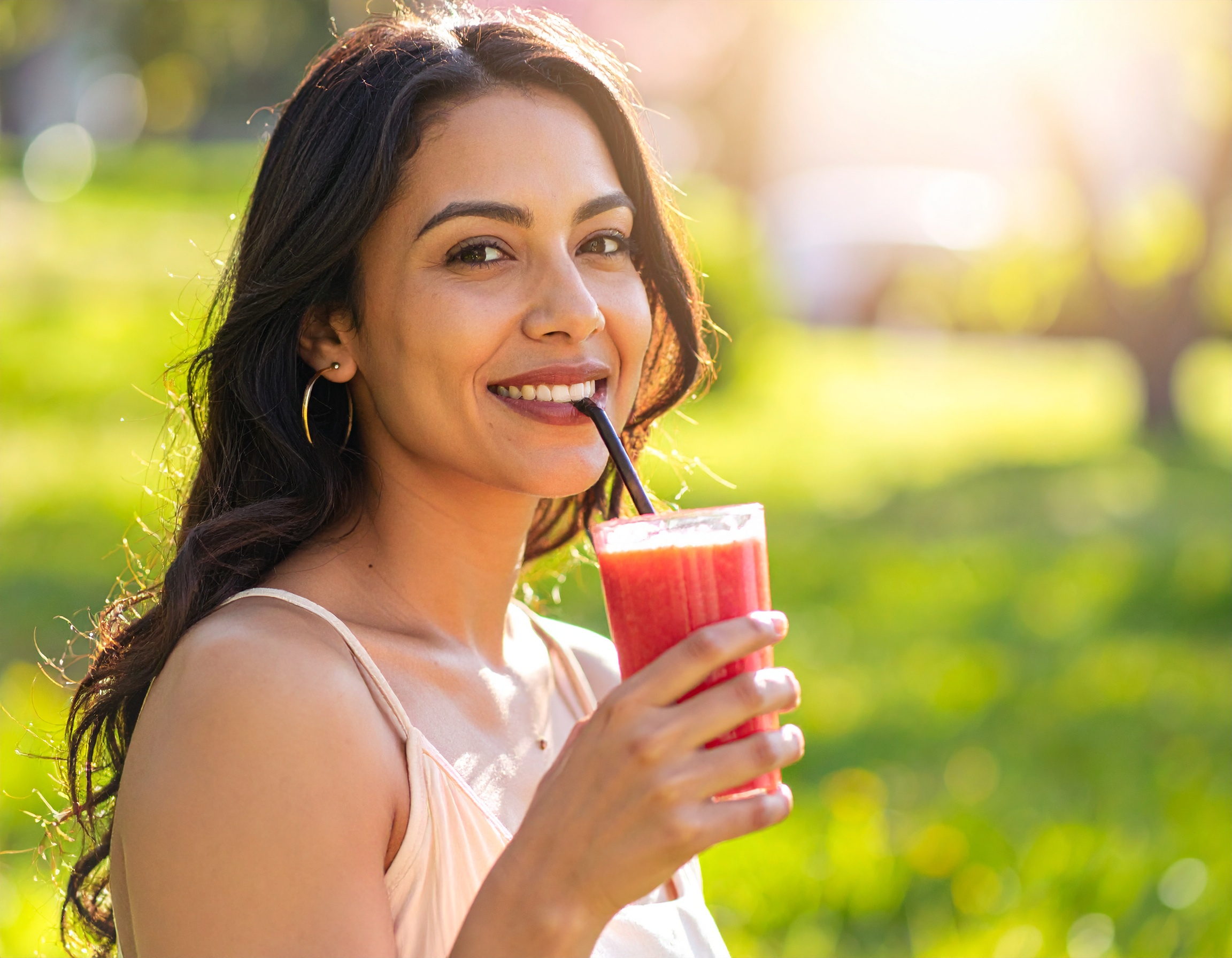 Person enjoying a healthy smoothie outdoors in spring, representing natural ways to strengthen the immune system